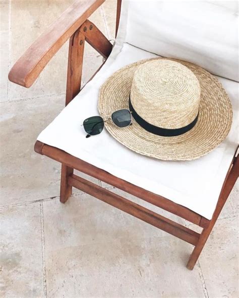 A Straw Hat And Sunglasses Sitting On A Chair