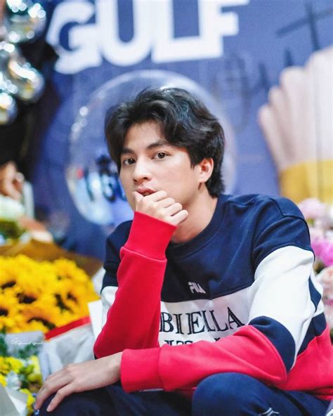 A Man Sitting On The Ground With Flowers In Front Of Him And His Hand