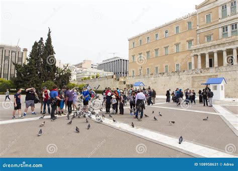 People Feeding Pigeons In Front Of The Athens Parliament Editorial