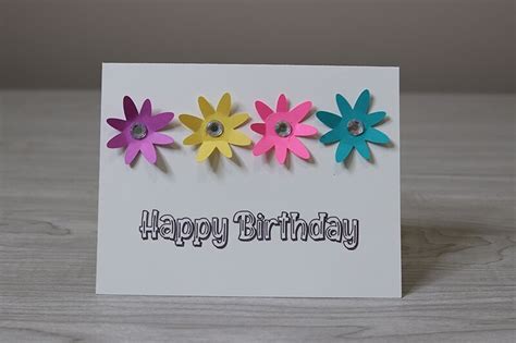 A Birthday Card With Three Colorful Flowers On It