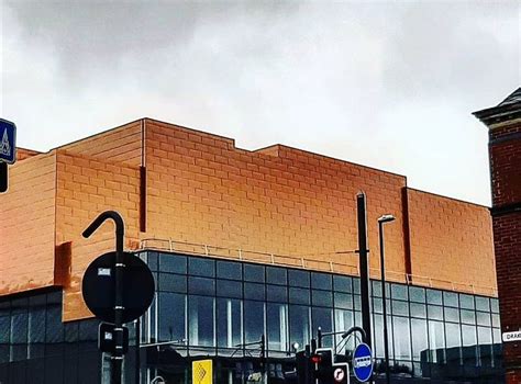 An Orange Brick Building On The Corner Of A Street With Traffic Lights