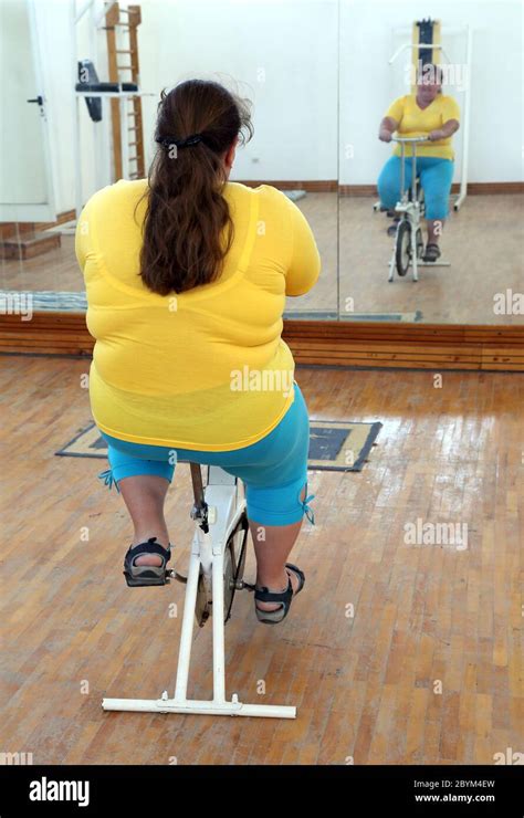 Overweight Woman Exercising On Bike Simulator Stock Photo Alamy