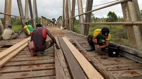 Warga Kampung Toray Perbaiki Jembatan Bersama Satga Yonif MR 411