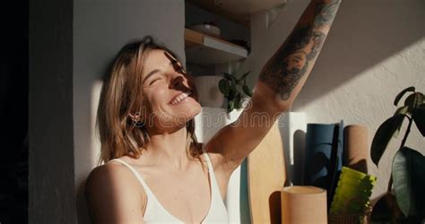 A Blonde Girl In A Sunny Room Reaches For The Rays Of The Sun Surrounded By Indoor Plants Stock