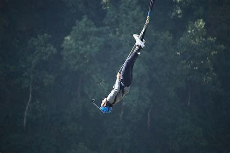 Premium Photo Low Angle View Of Man Jumping Against Trees