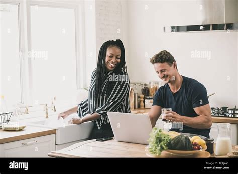 Happy Married Interracial Couple Looking At Laptop Computer Together