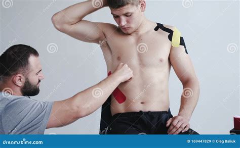 Athlete Receiving Kinesiology Tape Therapy From Therapist In Hospital