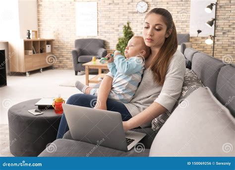 Young Mother Holding Baby While Working At Home Stock Photo Image Of
