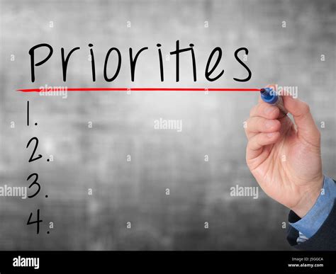 Business Man Hand Writing Priorities List With Marker Isolated On Grey