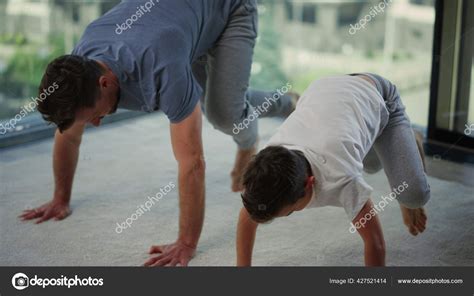 Sporty father and son training together. Dad and child doing workout at ...