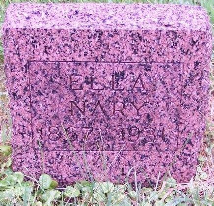 A Headstone In The Grass Near Some Flowers