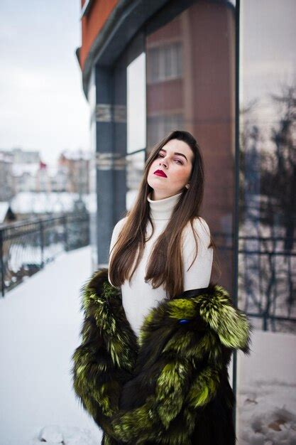 Premium Photo Brunette Girl In Green Fur Coat At Street Of City Against House With Large