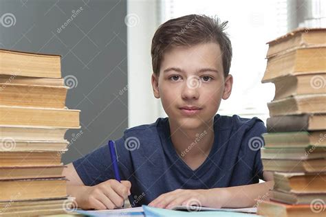 Boy Studing At Table On Blue Background And Many Book Stock Image