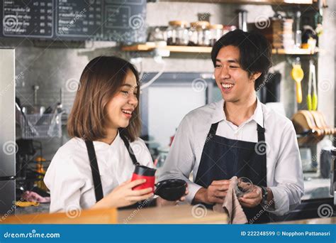 Two Asian Coffee Waitress Making Cup Of Hot Coffee Latte In Coffee Shop