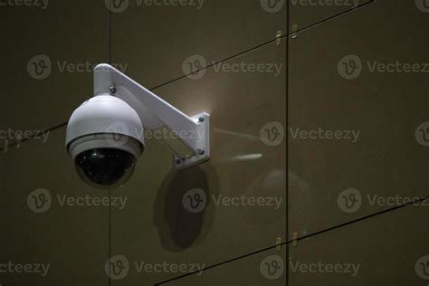 360 degree ball surveillance security camera on building wall at night ...