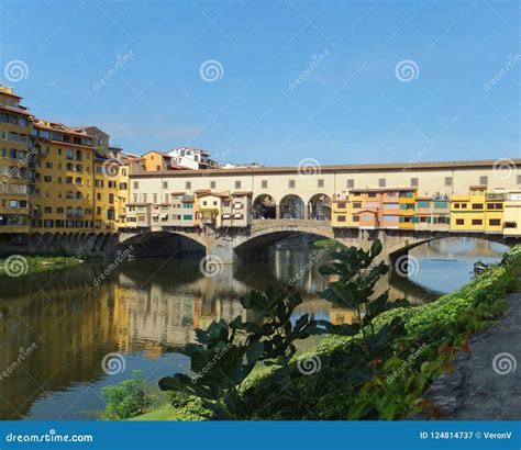 The Bright Coloured Ponte Vecchio In Florence Italy Reflected In The