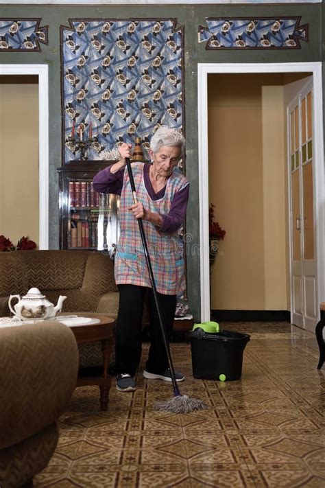 Ltere Frau Mit Dem Mopp Der Den Boden Aus Ihrem Haus Macht Stockfoto