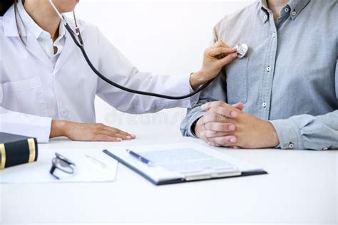 Female Doctor Checking Heart Beat Of Patient And Recommend Treat Stock