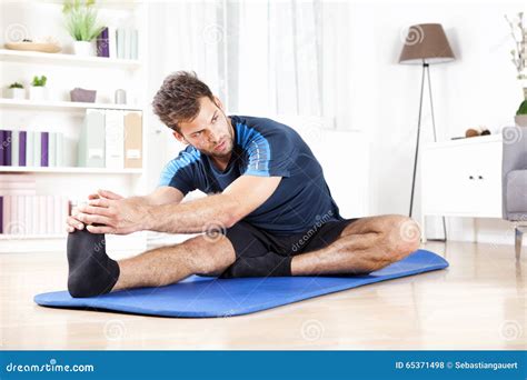 Gorgeous Man Performing Hamstring Stretch At Home Stock Photo Image