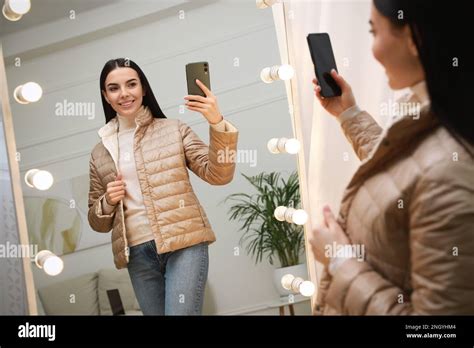 Young Woman Taking Mirror Selfie In Stylish Outfit At Home Morning