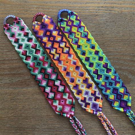 Three Different Colors Of Beaded Lanyards Sitting On A Table Next To