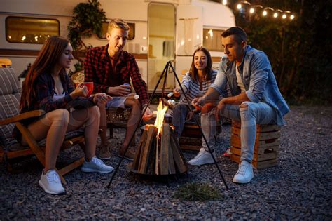 Friends having fun by campfire, picnic at camping | Stock image | Colourbox