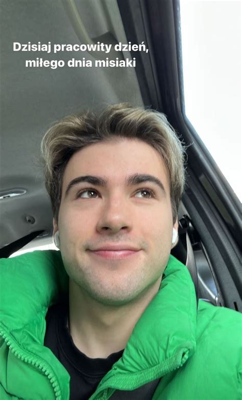 A Man Sitting In The Passenger Seat Of A Car Looking At The Camera With