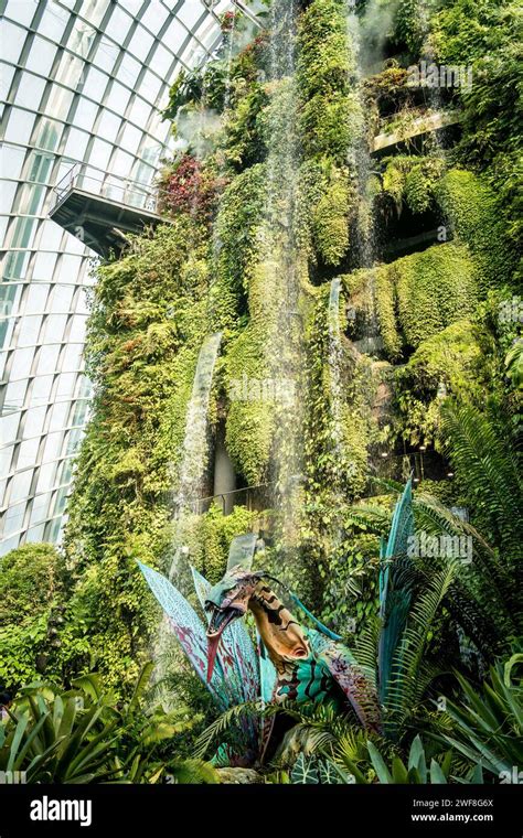 Visitors Observing An Indoor Garden S Magnificent Waterfall At Gardens