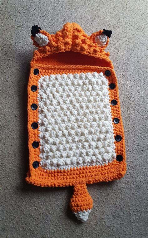 An Orange And White Crocheted Bag Laying On The Floor