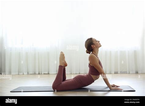 Young Woman Practicing King Cobra Asana In Yoga Studio Raja