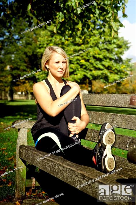 Woman Bending Leg On Park Bench Stock Photo Picture And Royalty Free