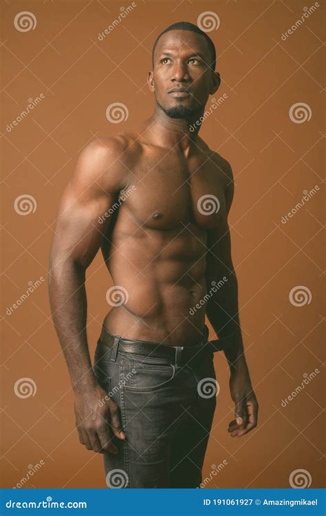 Bel Homme Africain Musculaire Torse Nu Sur Le Fond Brun Image Stock