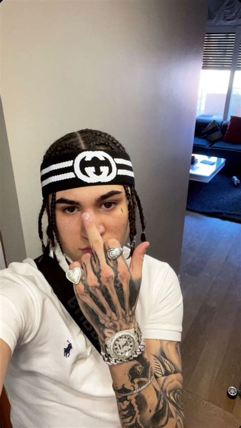 A Man With Dreadlocks And Tattoos On His Hand Is Taking A Selfie