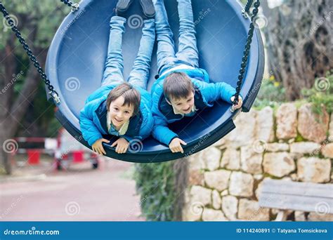 Two Preschool Children In A Swing Having Fun Stock Image Image Of