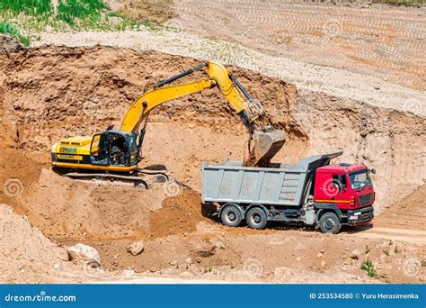 An Excavator In A Sand Pit Loads A Dump Truck With Sand Extraction Of Sand In An Open Pit Stock