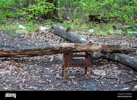 A Rusted Disposable Barbecue Grill Thrown Near A Fire In Nature Stock