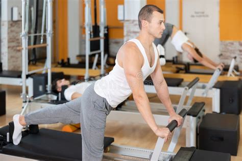 El Hombre Trabaja En El Gimnasio Y Realiza Ejercicios Para Estirar Los