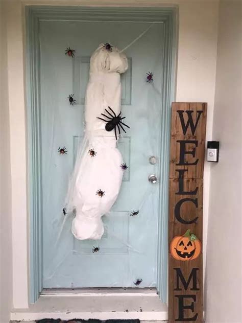 A Door Decorated For Halloween With A Spider And Webman On It S Back