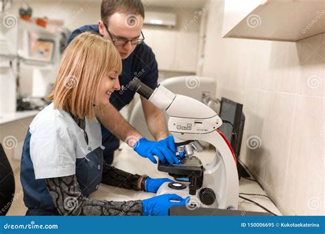 Los Ayudantes De Laboratorio Analizan La Muestra Que Mira A Trav S Del