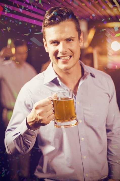 Composite Image Of Smiling Man Holding Glass Of Beer In Bar Stock Image