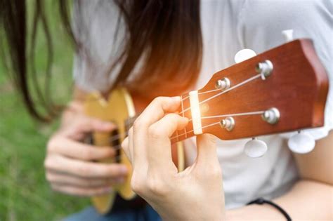 Premium Photo Midsection Of Woman Playing Ukulele On Grass