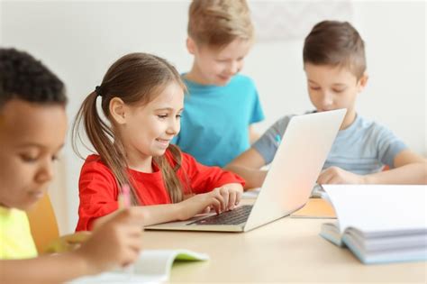 Niños lindos haciendo la tarea en el aula en la escuela Foto Premium