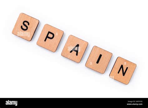 The Word Spain Spelt With Wooden Letter Tiles Over A White Background