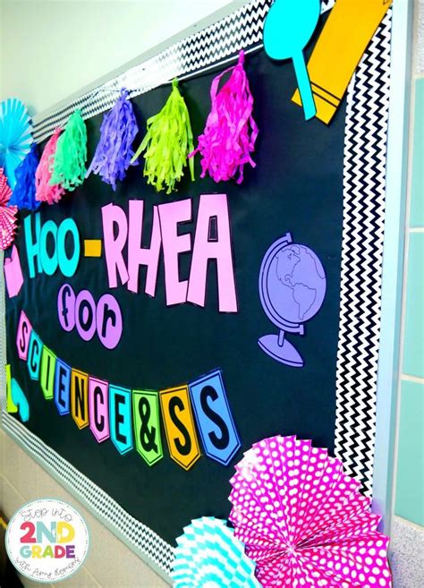 A Blackboard With Colorful Writing On It And Some Paper Fans In Front Of It