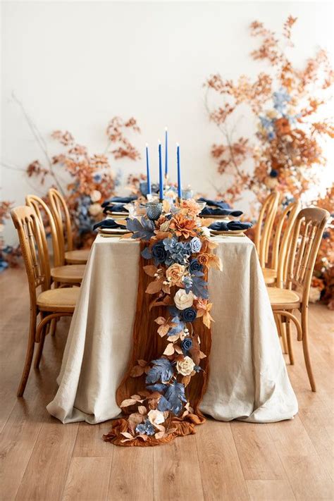 The Table Is Decorated With Blue And Orange Flowers