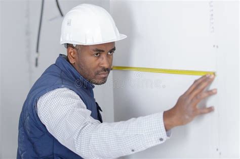 Hombre Que Mide La Pared Con Cinta De Medida Imagen De Archivo Imagen