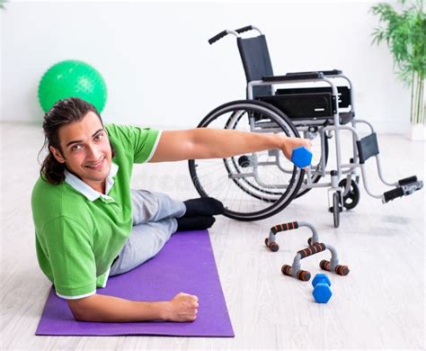 Joven En Silla De Ruedas Haciendo Ejercicios En Casa Foto De Archivo