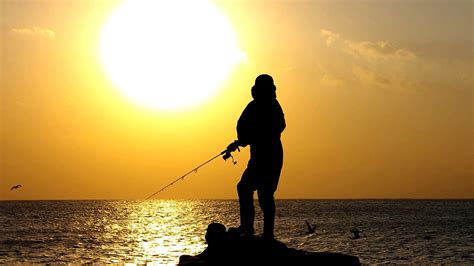 person fishing   shore  sunset image  stock photo public