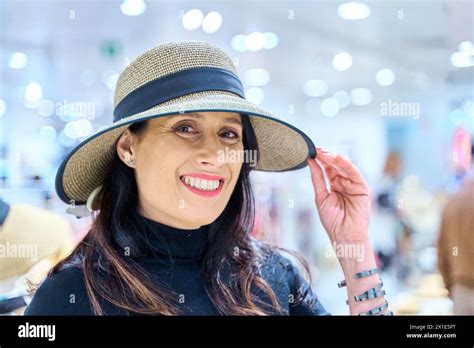Portrait Of A Mature Brunette Woman Wearing A Hat And Smiling And