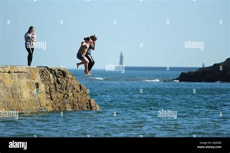 People Enjoying The Unseasonably Warm Weather By Jumping Into The Sea